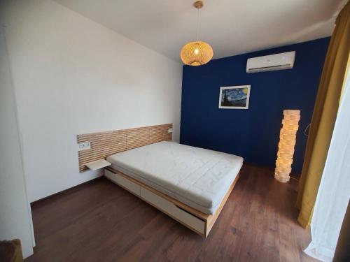 a small room with a bed and a blue wall at Вила Винсент - Villa Vincent in Lozenets