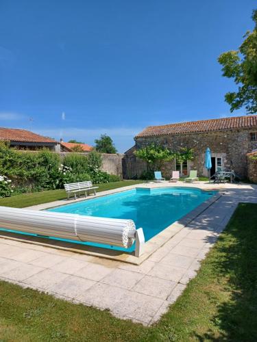 une piscine devant une maison dans l'établissement Le Prieuré Saint Pierre, gîtes et chambres d'hôtes dans un parc classé, à Réaumur