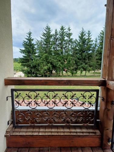 a bench on a balcony with a view of trees at Ebner Pince - Panzió in Turbékpuszta
