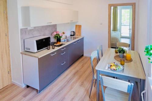 a kitchen and dining room with a table and a microwave at Villa Gréta in Siófok