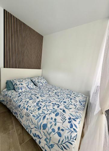 a bedroom with a bed with a blue and white comforter at Apartamentos y Lofts Makana in Playa Blanca