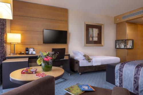 a hotel room with a couch and a bed at Maritim Hotel Düsseldorf in Düsseldorf