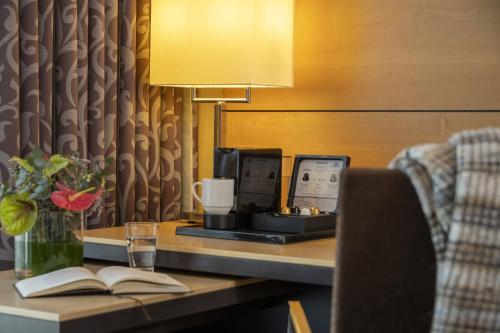 a desk with a computer and a book on it at Maritim Hotel Düsseldorf in Düsseldorf