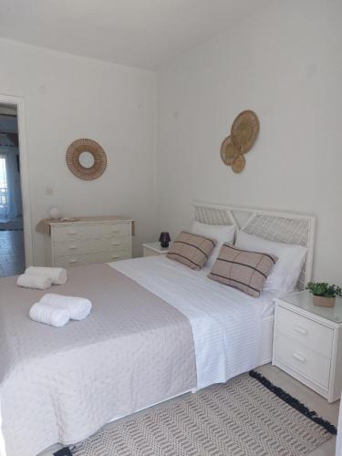 a bedroom with a large white bed with two pillows at Salt & Pine in Kallithea Halkidikis