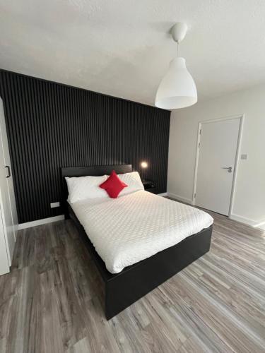 a bedroom with a bed with a red pillow at YUGOGO 37 London Road - Studio in Saint Albans