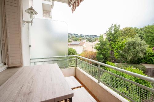 d'un balcon avec une table en bois et une vue. dans l'établissement Selvosa 1 bedroom apartment heart of Cannes, à Cannes