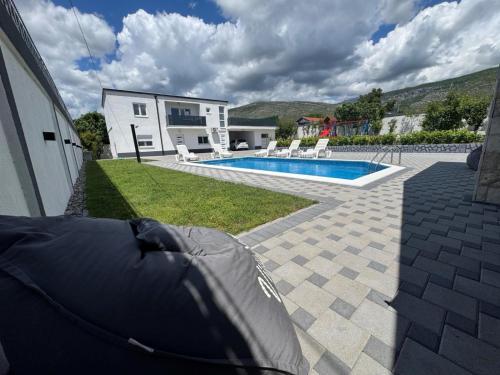 une cour arrière avec une piscine et une maison dans l'établissement Villa Sara, à Blagaj
