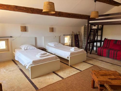 - une chambre avec deux lits et un canapé rouge dans l'établissement Mas la Provinciale, à Malaucène