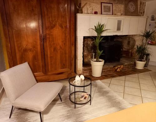 a living room with a chair and a fireplace at Le Nid de Condat, Dordogne in Condat-sur-Trincou