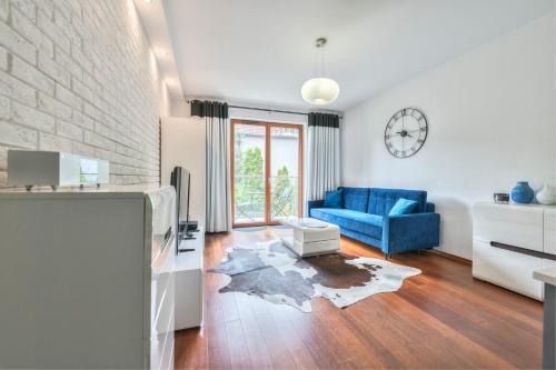 un soggiorno con divano blu e sedia blu di Sopot Kamienny Potok by NorthSide Apartments a Sopot
