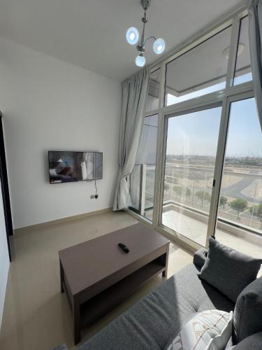 a living room with a couch and a large window at Wonderful Rental Apartments in Dubai Silicon Oasis in Dubai
