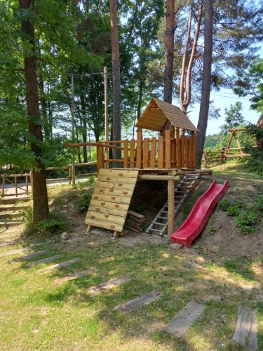 a wooden playground with a slide and a play structure at Chata Očovan in Zvolen