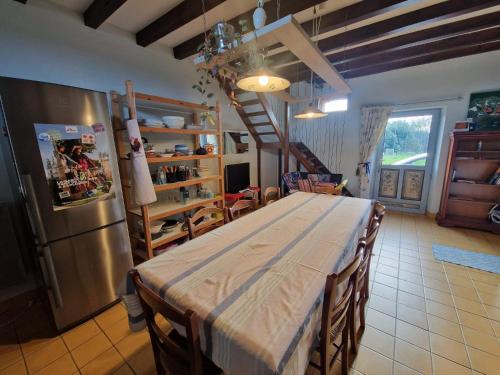 una cucina con tavolo e frigorifero di La Petite Foucaudière, 10 couchages a Mansigné