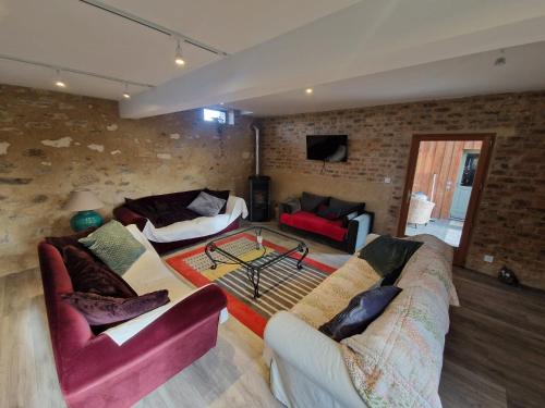 - un salon avec deux canapés et un mur en briques dans l'établissement La Petite Foucaudière, 10 couchages, à Mansigné