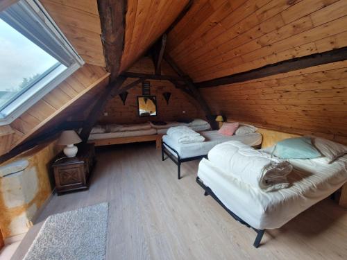 Camera mansardata con 2 letti e un tavolo. di La Petite Foucaudière, 10 couchages a Mansigné