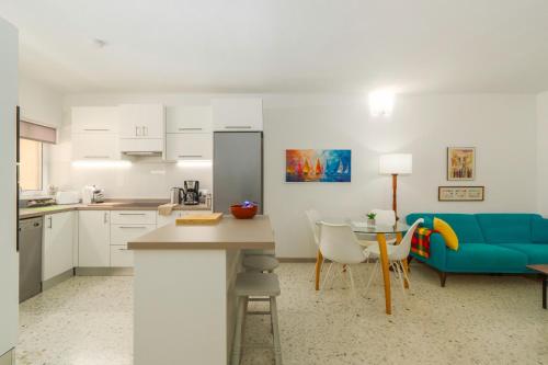a kitchen and living room with a blue couch and a table at No 25, in Marsaskala