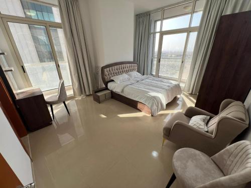 a bedroom with a bed and a couch and chairs at Dubai Silicon Oasis Rental Apartments in Dubai