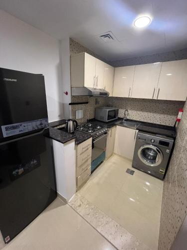 a small kitchen with a stove and a dishwasher at Wonderful Rental Apartments in Dubai Silicon Oasis in Dubai