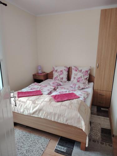 a bedroom with a bed with pink sheets and pillows at Margit kulcsoshaz in Rareş
