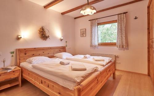 a bedroom with a large wooden bed with white sheets at Chalet Mallnock by Globalimmoservice in Bad Kleinkirchheim