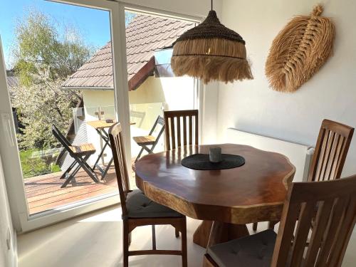 a dining room with a table and chairs and a balcony at Am Fluss-Ufer - nur 5 Minuten zum Europapark und direkt am Naturschutzgebiet in Kappel-Grafenhausen