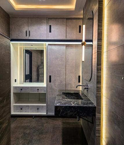 a bathroom with a sink and a mirror at The White Suites in Karachi