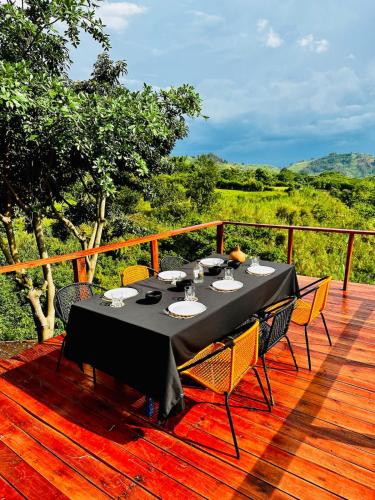 a black table with chairs on a wooden deck at Kasana Lake House in Isunga