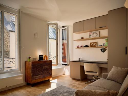 un salon avec un canapé, un bureau et une fenêtre dans l'établissement Studio cosy et calme Paris 17 Batignolles, à Paris