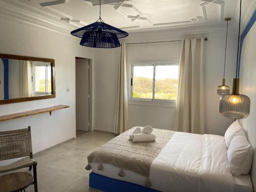 a bedroom with a bed and two blue pendant lights at Little Wing in Diabat