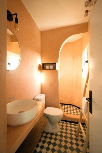 a bathroom with a white toilet and a sink at Little Wing in Diabat