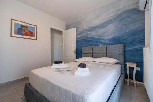 a bedroom with a large bed with a painting on the wall at Horizon Luxury Living Breathtaking Seaview Minutes from the Airport in Artemida