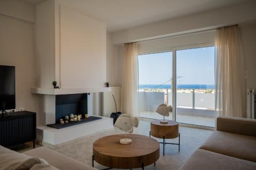a living room with a couch and a fireplace at Horizon Luxury Living Breathtaking Seaview Minutes from the Airport in Artemida