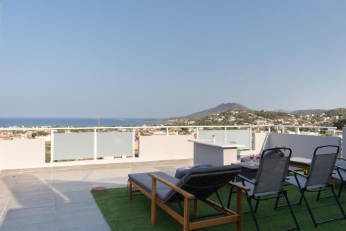a patio with a table and chairs on a roof at Horizon Luxury Living Breathtaking Seaview Minutes from the Airport in Artemida