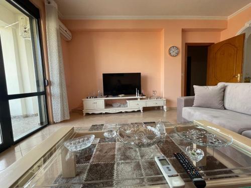 a living room with a couch and a tv at Dukas apartment in Korçë