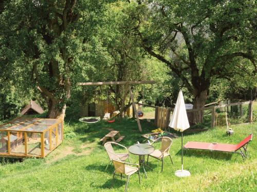 a backyard with a table and chairs and an umbrella at VOM REITER, Ferienwohnung am Bauernhof mit Bergblick und privater Infrarotkabine, Inklusive Sommercard in Schladming