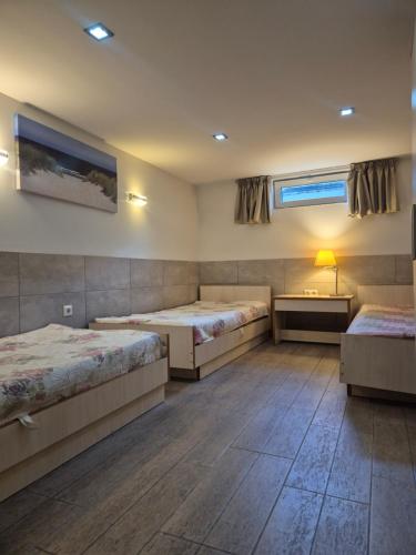 a bedroom with two beds and a table and a window at Palanga S3 in Palanga