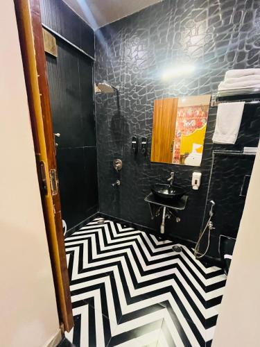 a bathroom with a black and white checkered floor at Stay Banaras - A Boutique Hotel in Varanasi