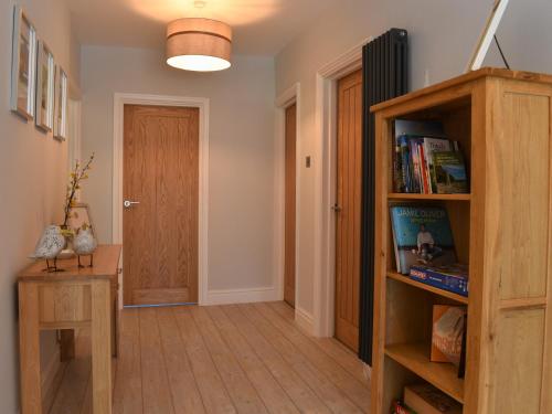 a hallway with a book shelf and a door at Ted's Place in Arnside