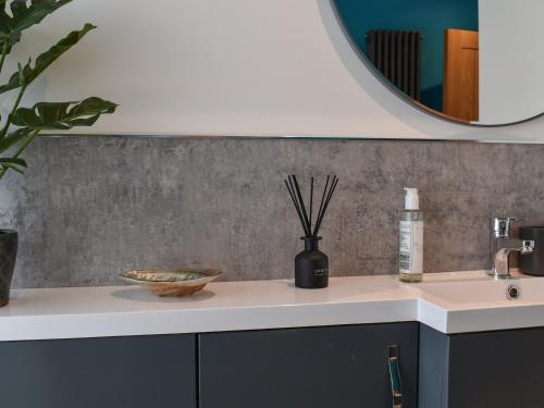 a bathroom counter with a sink and a mirror at Ted's Place in Arnside
