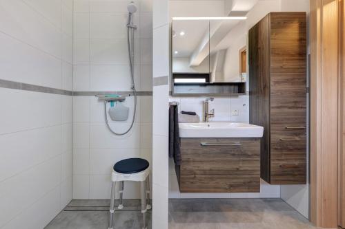 a small bathroom with a sink and a stool at Haus Tina in Oesterwurth