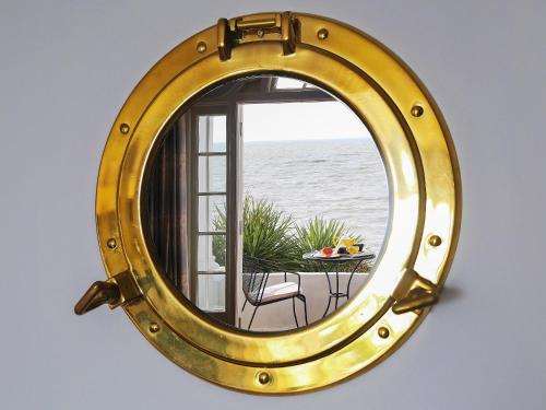a large gold mirror hanging on a wall at Seashore Apartment in Sandgate