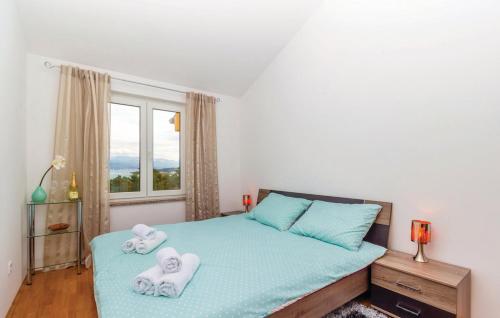 a bedroom with two towels on a bed with a window at Sea view apartment in Čižići