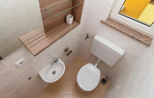 a bathroom with a white toilet and a sink at Sea view apartment in Čižići