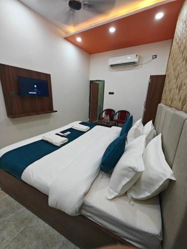 a bedroom with a large white bed with blue pillows at Hotel The R L Palace - "A Luxurious Hotel" 900 Meters From Ram Mandir Ayodhya in Ayodhya