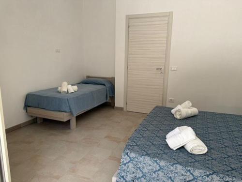 a bedroom with two beds with towels on them at Agriturismo Le Ville con Piscina idromassaggio, Capo Vaticano in Ricadi