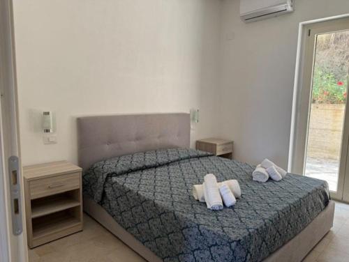 a bedroom with a bed with two towels on it at Agriturismo Le Ville con Piscina idromassaggio, Capo Vaticano in Ricadi