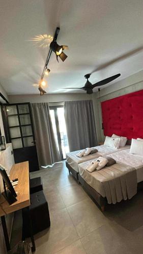 a bedroom with a large bed with a red headboard at Old Cinema Suites - Stylishly Decorated Retreat with Pool or Jacuzzi by the Sea in the Heart of Laganas Βy Villa Mana Gers in Laganas