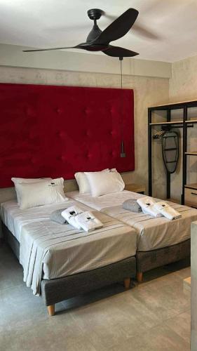a bedroom with a large bed with a red headboard at Old Cinema Suites - Stylishly Decorated Retreat with Pool or Jacuzzi by the Sea in the Heart of Laganas Βy Villa Mana Gers in Laganas