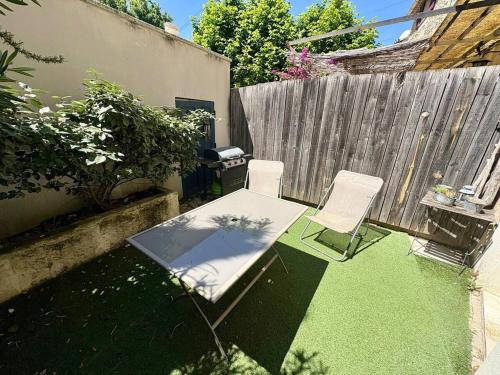 une cour avec une table, des chaises et une clôture dans l'établissement Villa Lavensa, à Saint-Rémy-de-Provence