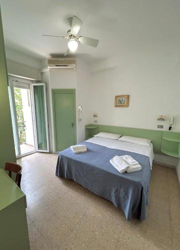 ein Schlafzimmer mit Bett und Deckenventilator in der Unterkunft Hotel Caracas in Cattolica